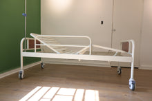cama de hospital manual con cabecera y piesera elevadas, vista lateral