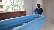 Paciente dentro de una bañera portátil, con un cuidador a su lado. La imagen muestra la funcionalidad y el confort que ofrece la bañera portátil en la atención personal y la higiene.