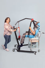 cuidadora traslada al paciente al cómodo con ayuda de la grúa para pacientes con sobrepeso