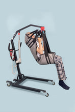 hombre suspendido en grúa para pacientes eléctrica inalámbrica, usando un arnés de rehabilitación Victoria- Vista lateral derecha