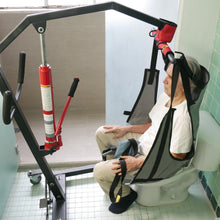 Paciente siendo asistido con una grúa para pacientes para utilizar el inodoro