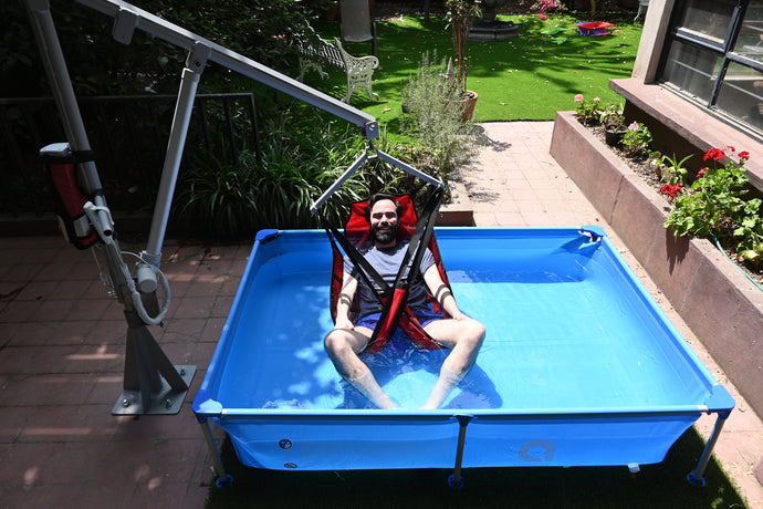Hombre en alberca utilizando la grúa de alberca Aquaton 