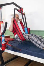 paciente usando arnés cambia pañal levantado con grúa para pacientes