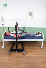 paciente acostado usando un arnés cambia pañal y la grúa para pacientes