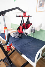paciente en posición acostada usando el arnés para cambio de pañal en cama con las piernas elevadas